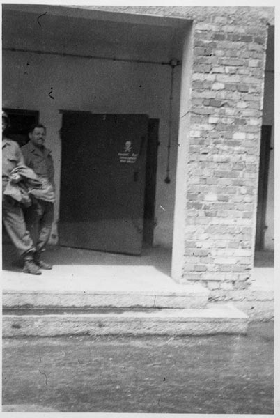 Photograph taken by Eisenstein during his brief visit to Dachau in 1945. A crematorium can be seen, with a skull and cross bone warning sign visible on the door.