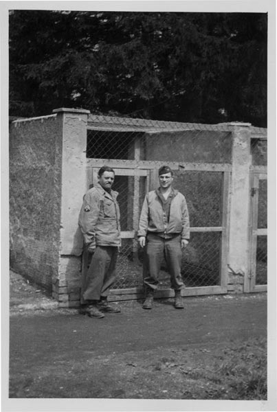 Eisenstein, on the right, with a Yiddish and Hebrew speaking military companion in front of dog pens at Dachau. After speaking with camp victims, they learned that large dogs were frequently set loose upon the people in the camp.