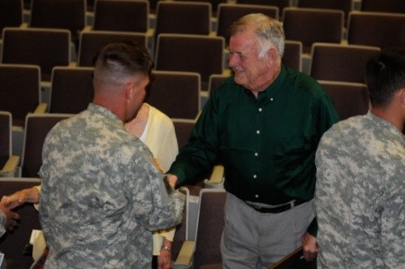Jimmy Gentry shakes hands with soldiers of the 101st Sustainment Brigade following his story at the “Holocaust Day of Remembrance” at Wilson Theater, in Clarksville, Tennessee, April 16, 2012. Gentry spoke to the soldiers about the impact that April 29, 1945, had on his life; that day his unit in World War II liberated the Dachau concentration camps and its 32,000 surviving detainees.