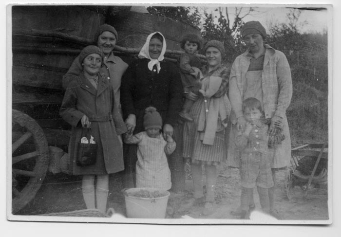Hanna Hamburger, age five, clutching a purse and smiling, with one of the family’s housemaids and other villagers while picking grapes near Eppingen, Germany.