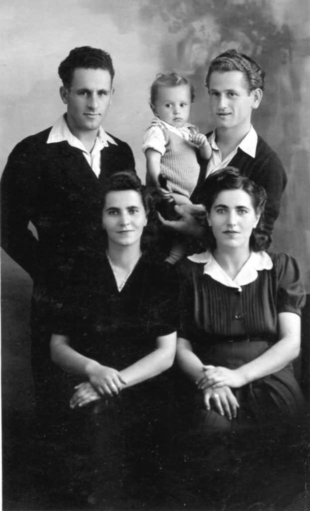 David Naft, and Jack Seidner holding Leon, standing; Lea Naft and Sara Seidner, seated. Family portrait taken in Cremona, Italy, in 1947.